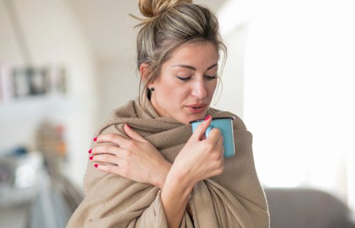 Premier AC & Heating LLC | Rock Hill, SC | woman wrapped in blanket sipping hot beverage in cold house